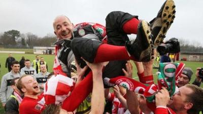 Manager Tommy Breslin is lifted by the players after Cliftonville won the Irish Premiership