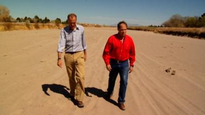 Men walk in dried up Rio Grande River