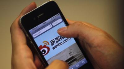 Man using iPhone showing weibo microblogging site (file photo)