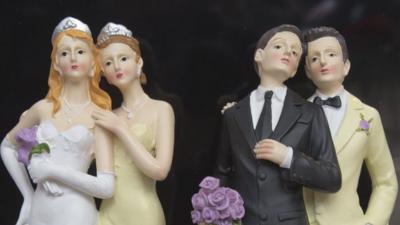 Plastic figurines depicting a female couple and a male couple