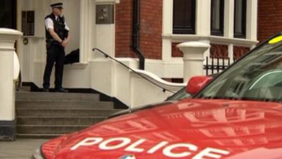 An officer outside the Ecuadorean Embassy