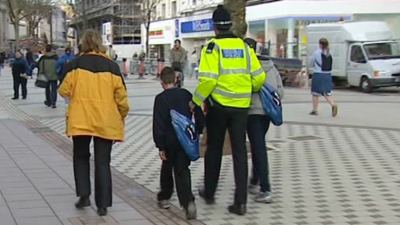 Police and education officer stop and talk to two boys