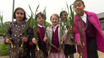 Children holding leeks