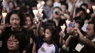 A child (C) takes part in a candlelight vigil held to mark the 24th anniversary of the 1989 crackdown at Tiananmen Square, in Hong Kong, on June 4, 2013