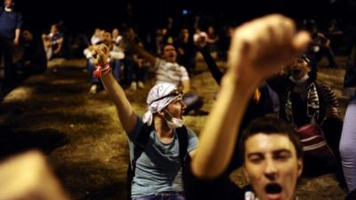 Turkish protesters chant slogans as they confront with Turkish riot policemen