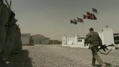 Soldier walks past memorial wall in Kabul barracks