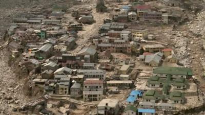 Badly damaged buildings in mud