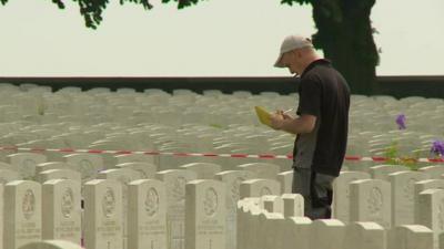 Man inspecting gravestones