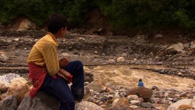 Boy and woman sitting near river