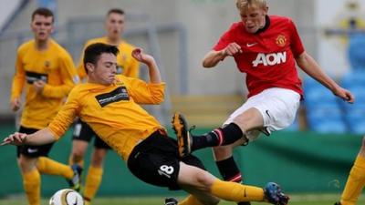 Co. Antrim's Michael McKenna in action against Oliver McBurney of Manchester United in the Premier Section