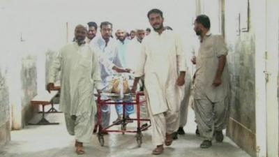 Men with wounded man on hospital trolley