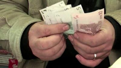 Shopkeeper counting euro notes