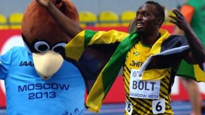 Usain Bolt celebrates with the official mascot of the World Championships