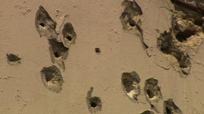 A wall riddled with bullets