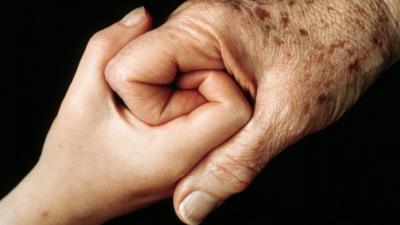 Older person holding hands with child