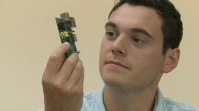 Joe Tidy looking at a computer chip board