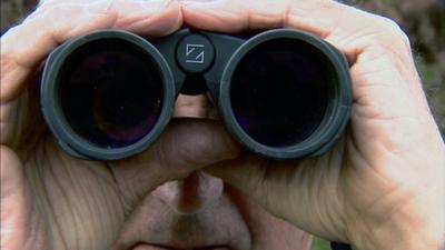 Man looking through binoculars