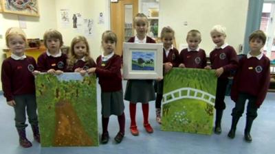 Children pose with paintings