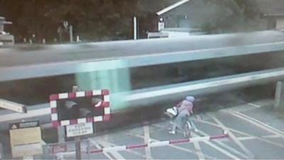 This shocking video shows a cyclist coming within seconds of being hit by a train at a level crossing in Cambridgeshire.