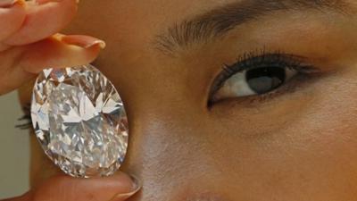 In this Thursday, Sept. 19, 2013 file photo, a 118.28-carat white diamond is displayed by a model at a press preview at Sotheby"s auction house in Hong Kong.