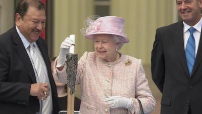 The Queen inserts her message into the Commonwealth baton; she'll read it at the opening ceremony of the games.