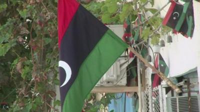 Flags hang on a building in Libya