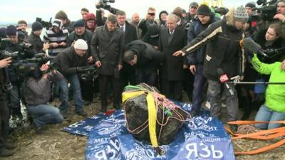 People crowd around a part of what is thought to be the Chelyabinsk meteor in Russia