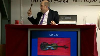 Auctioneer taking final bid on the Titanic violin