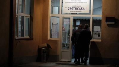 Kosovo police officers inspect vandalised polling station in Mitrovica