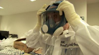 The BBC's Japan correspondent, Rupert Wingfield-Hayes, puts on a protective face mask as he prepares to go into the Fukushima nuclear plant