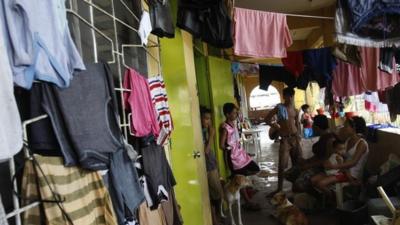 A family and their pet dogs sit in the balcony of a school compound used as a temporary shelter for survivors after the Super typhoon Haiyan battered Tacloban city in central Philippines