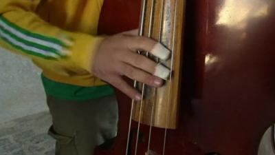 Hand on strings of double bass