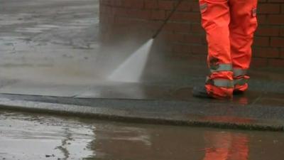 Workman cleans the road after the flooding