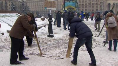 People try to break ice on the ground of Kiev's Independence Square