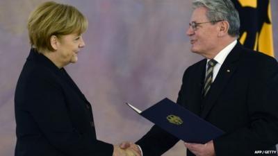 German President Joachim Gauck (R) hands over the certificate of appointment to German Chancellor Angela Merkel on December 17, 2013 at Bellevue Palace in Berlin