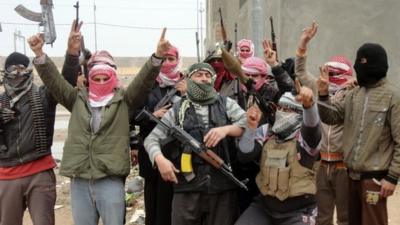 Iraqi men from local tribes brandish their weapons