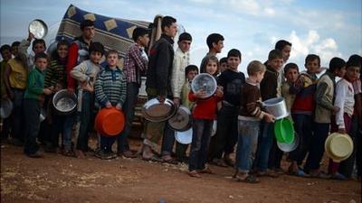 Displaced Syrian children line up for food distribution in the Maiber al-Salam refugee camp