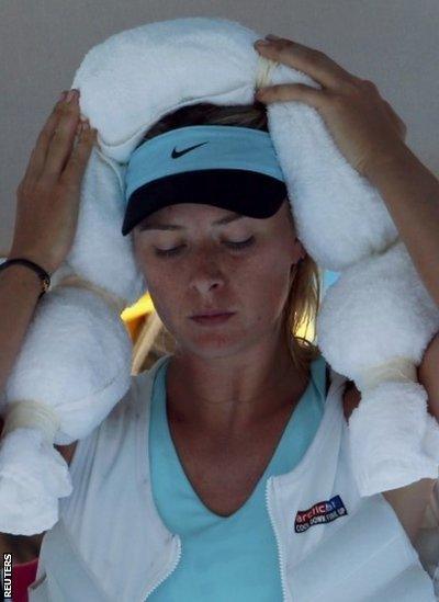 Maria Sharapova of Russia holds an ice-packed towel to her head while wearing an ice vest