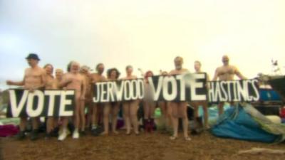 Nude people on a beach with a sign that reads "Vote Jerwood vote Hastings"