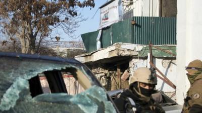 Afghan special forces soldiers stand guard next to the damaged entrance of a Lebanese restaurant that was attacked in Kabul