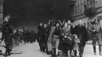 Civilians being escorted by German guards in the Warsaw Ghetto