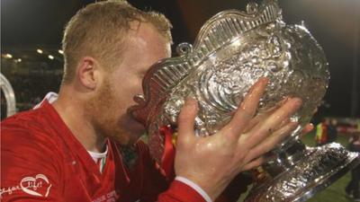 Cliftonville striker Liam Boyce has a drink from the trophy