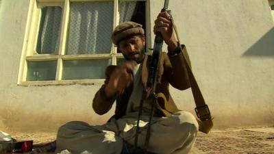 Afghan man cleaning and assembling his rifle