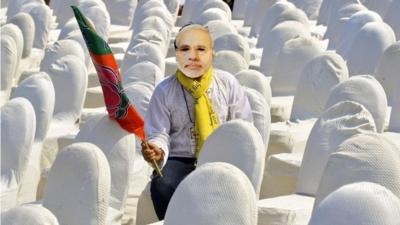 A volunteer of India"s main opposition Bharatiya Janata Party (BJP), wearing a mask of Hindu nationalist Narendra Modi