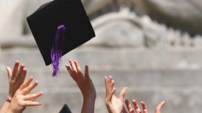 GRADUATES THROW UP HATS