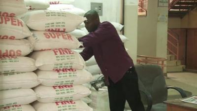 Man looks at bags of flour