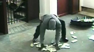 Thief picks up money from floor