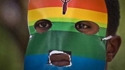 A Kenyan gay man wears a mask to preserve his anonymity as he protests against anti-gay moves in Uganda outside the Uganda High Commission in Nairobi, Kenya on 10 February