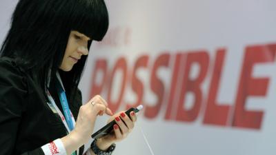 Woman holding mobile phone at Mobile World Congress