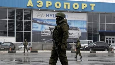 Armed men patrol outside of Simferopol airport, on February 28, 2014